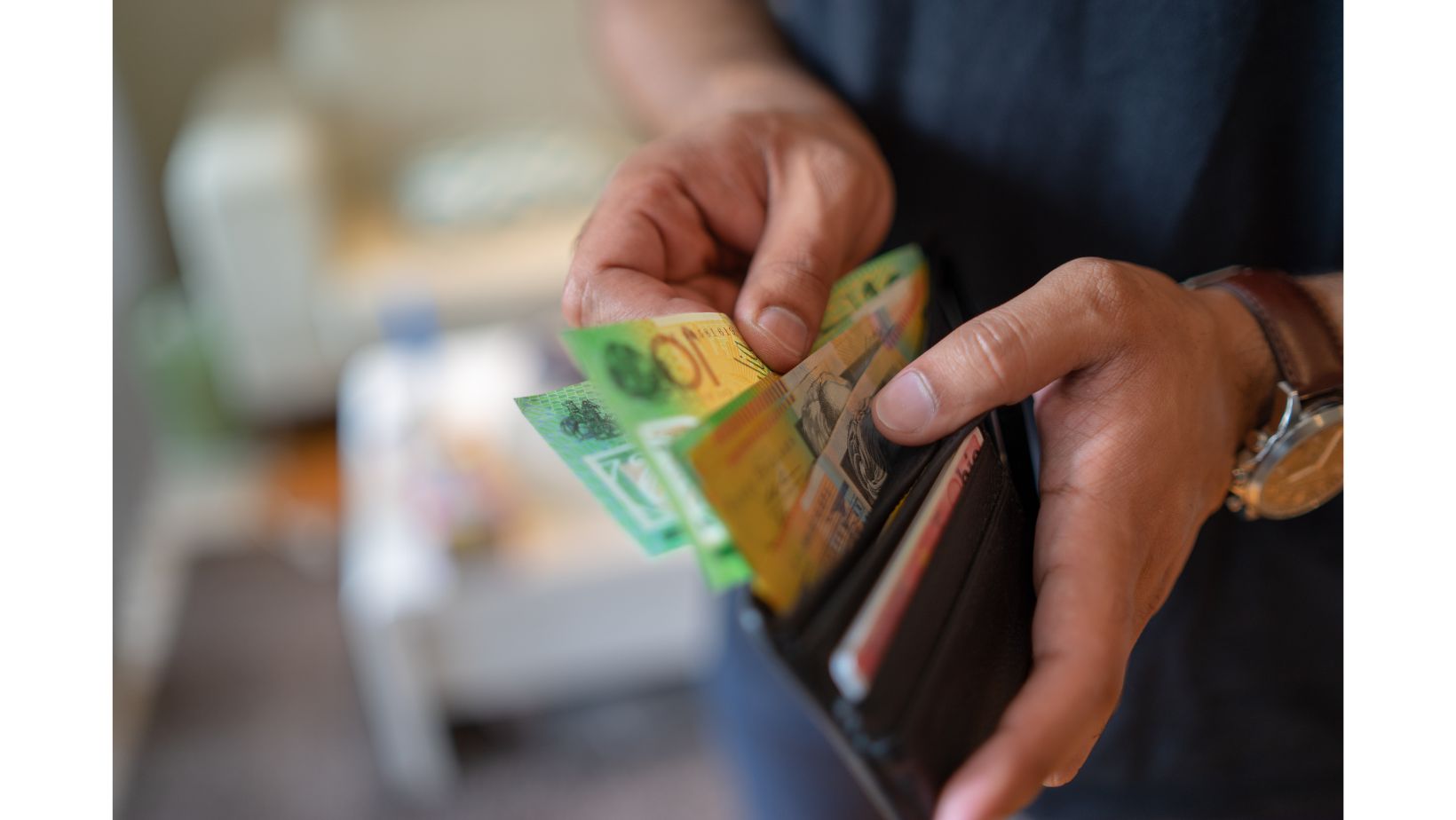 Um homem segurando uma carteira com dólares australianos