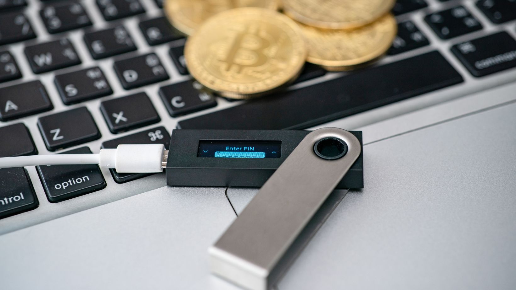 Hardveres kriptovaluta pénztárca arany bitcoinokkal egy laptopon